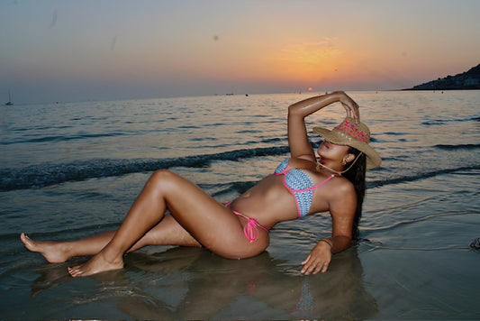 Look de plage chic avec le bikini brésilien Onda do Rio de Soleil Leblon et un chapeau de plage femme fait main par Mãhiera'a Boutique au coucher de soleil.