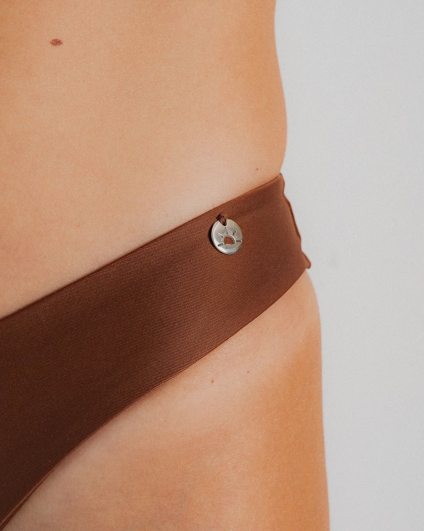 Détail médaille soleil bas maillot brésilien marron — Soleil Leblon®