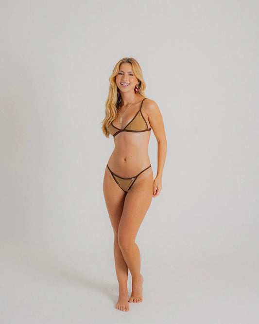 Mannequin portant un bikini deux pièces beige et marron à fines bretelles, avec détails contrastés et coupe échancrée, posé sur fond blanc minimaliste.
